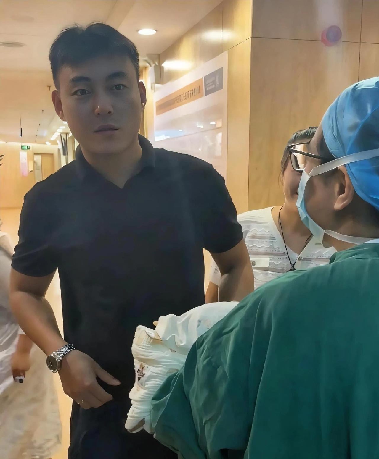 护士抱着刚出生的宝宝从产房里出来，见到孩子爸爸后，护士让他猜猜是男孩还是女孩，爸