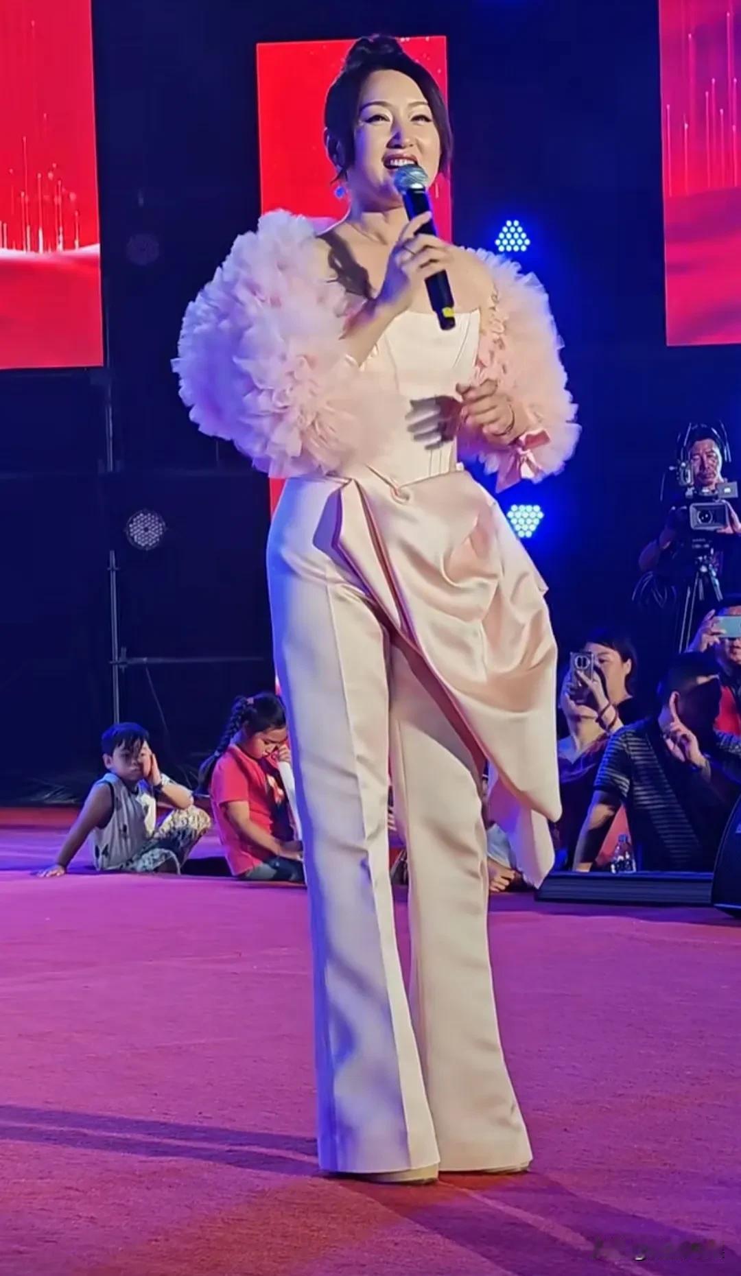 “甜歌皇后”杨钰莹现身商演，54岁的她，穿着一身粉色，脸肿脸僵，医美痕迹很明显，