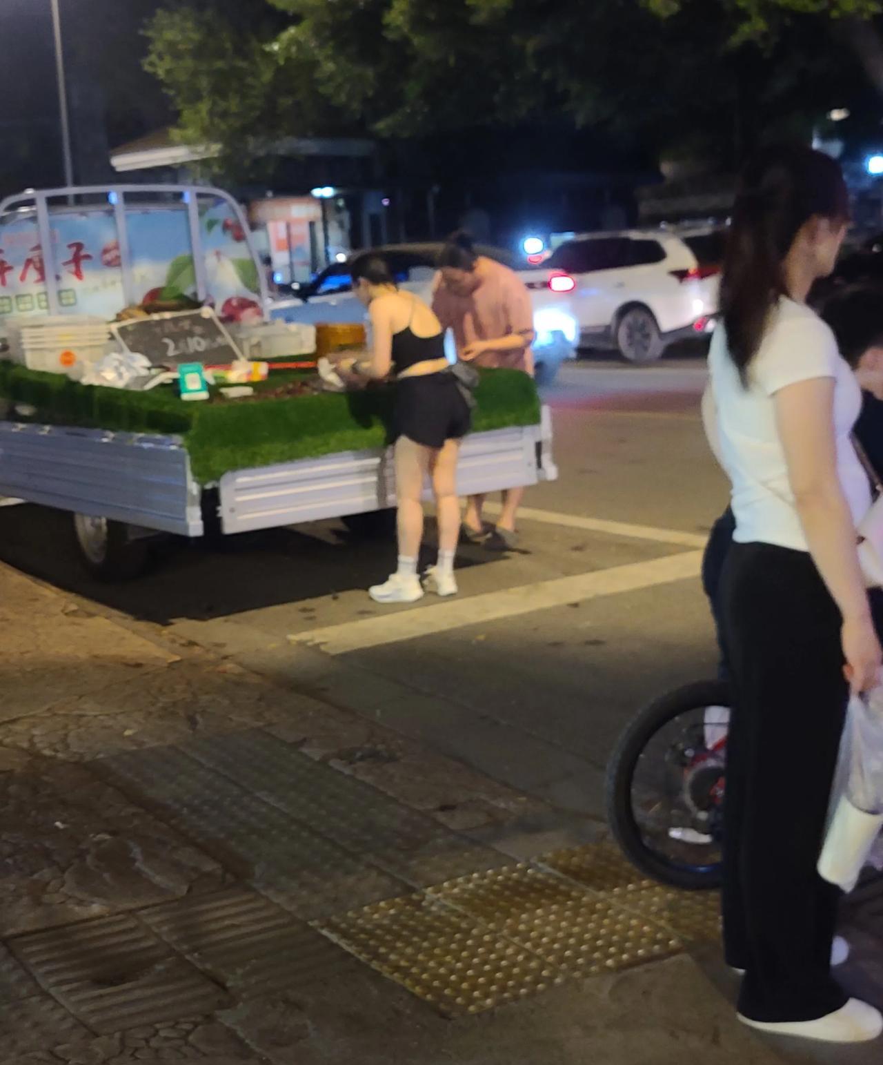 6月30日夜，随手拍。成都青羊，一男一女，在一家夜摊车上买“车厘子”。“车厘子”