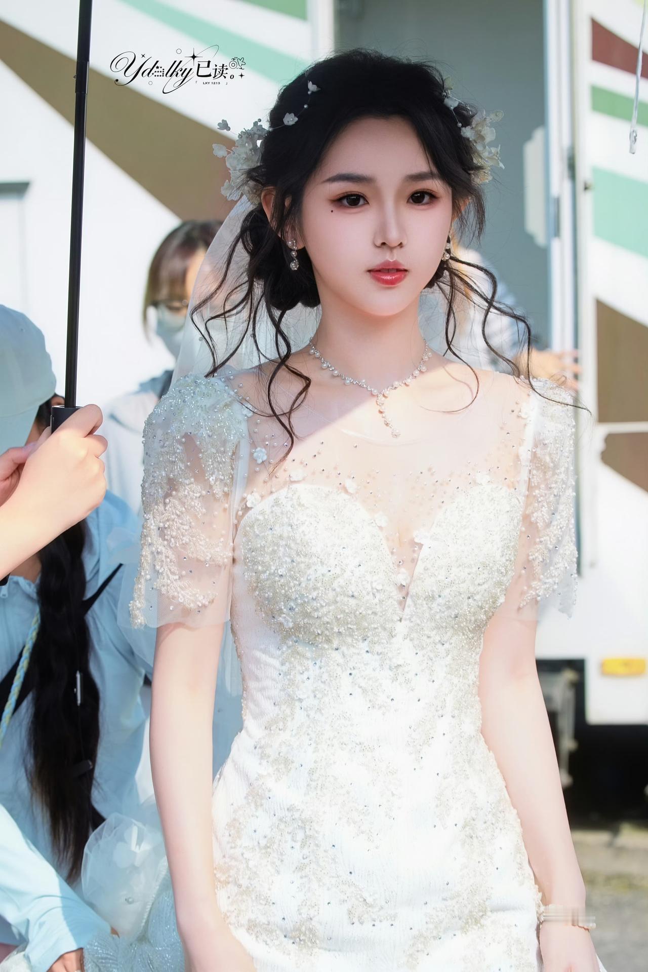 李柯以重工蕾丝钉珠婚纱，蓬松卷曲盘发，演绎温婉灵动的少女新娘