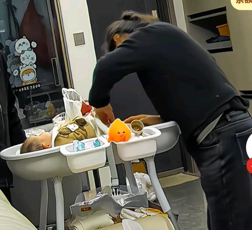 奶奶正在给孙子换纸尿裤，忽然孙子直接尿了奶奶一脸，奶奶也没嫌弃，甚至用手去接