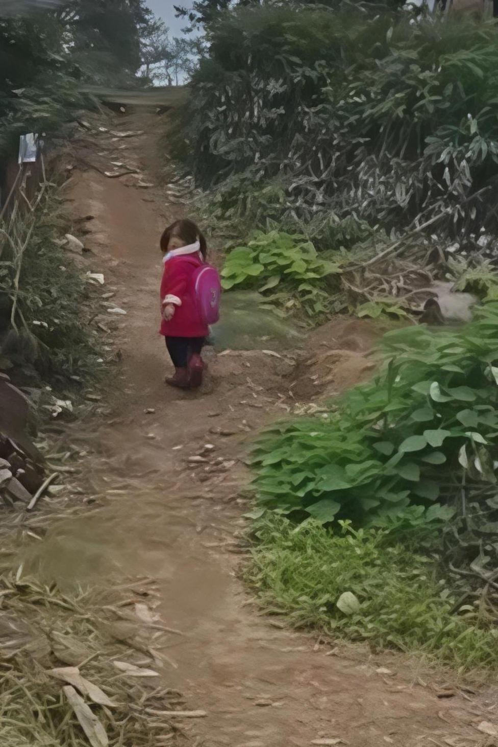 短短10米的土路，小姑娘走得很慢，小小的身影不住地回头，让跟在后面的老师眼里泛起