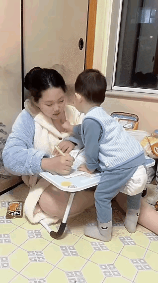 姐姐正在写作业，弟弟不老实的小手摸脸也就算了，关键还想试探肩胛骨，被姐姐一把推开