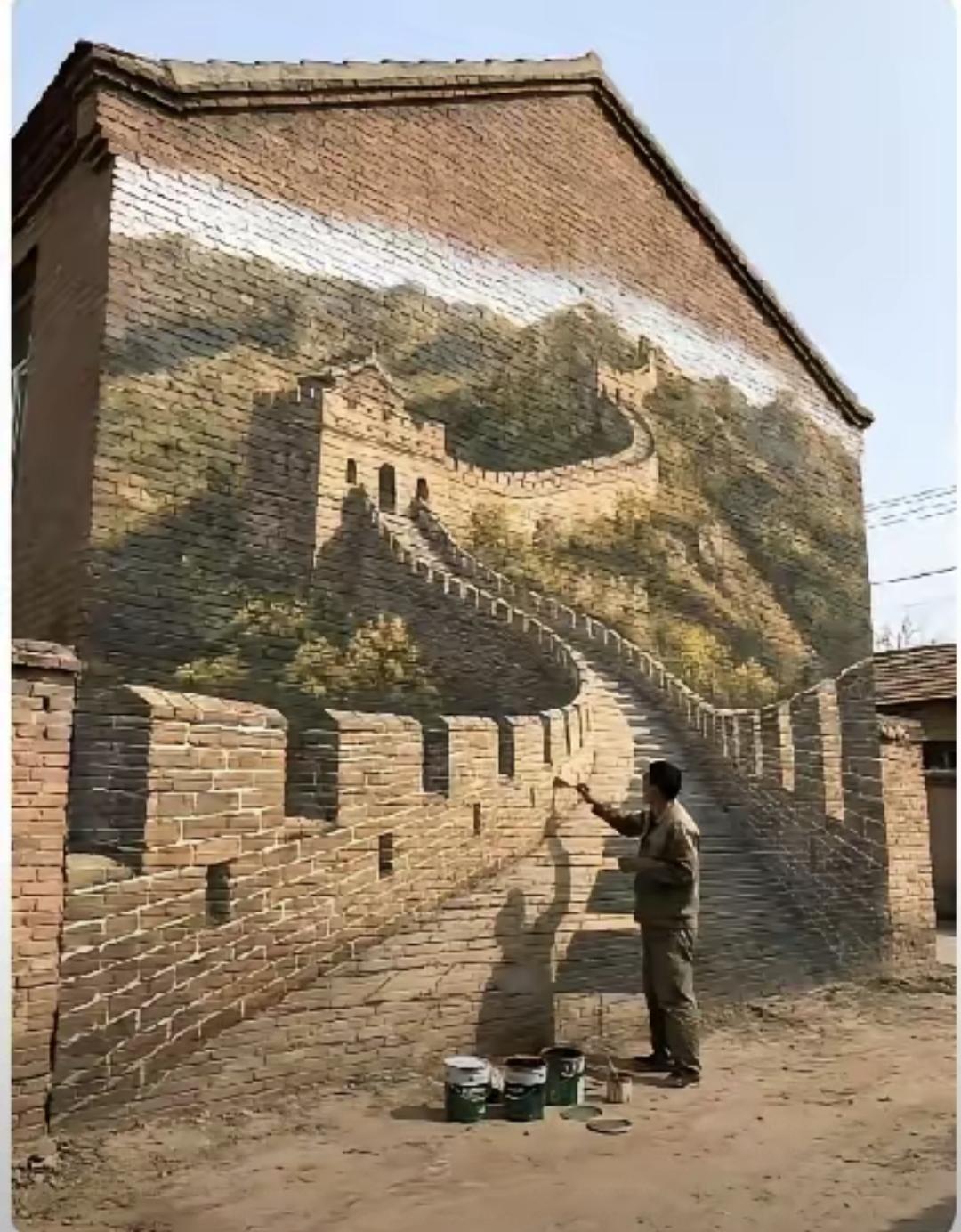 河南商丘吴营村的画家吴承言，最近又在村里的一面十米高墙上动手了。这次他画的是万里