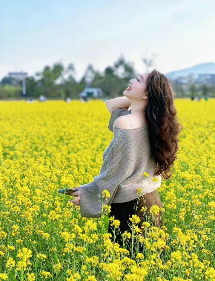 油菜花田一娇娘，半露香肩风也醉