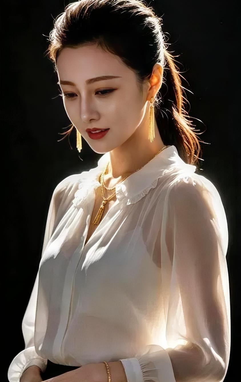 光影里的白衫流金纯白薄衫，轻拥柔光，金饰流苏，垂落温婉。高束马尾，利
