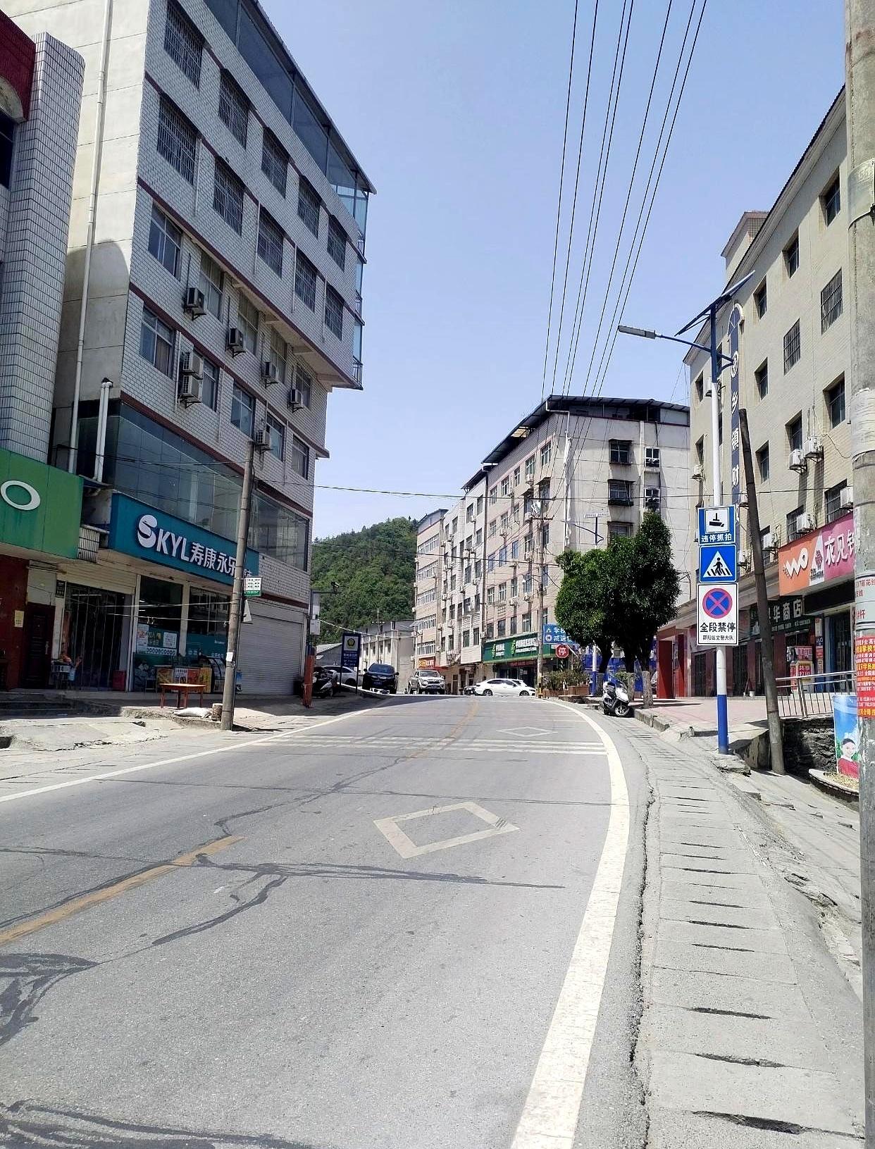 寿衣店里灯打得亮，老板娘一套套往前推，说绸的是有面子、麻的是规矩，家属在门口犹豫