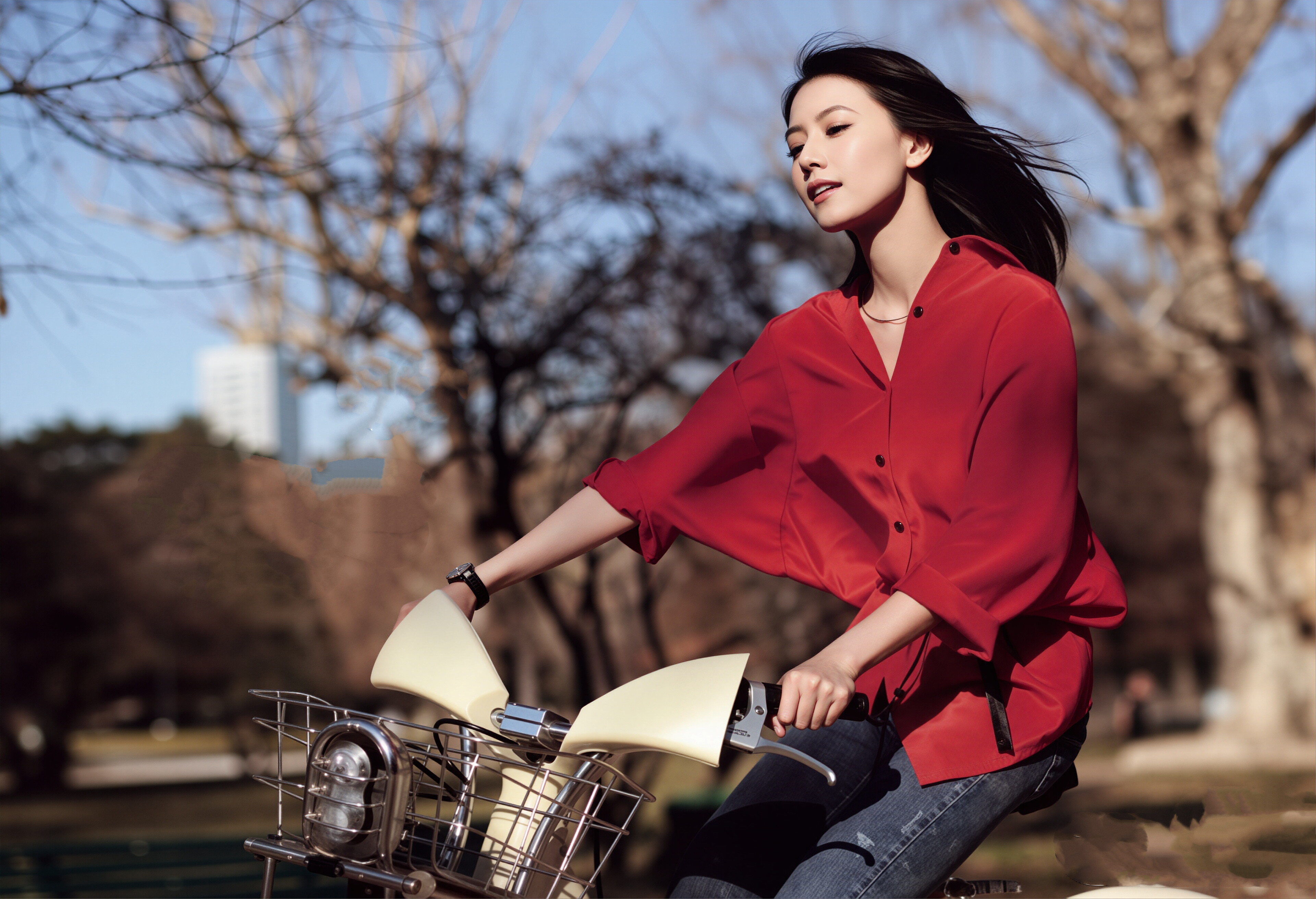 高圆圆骑上单车，红衬衫在春日里格外亮眼，发丝随风扬起，松弛感拉满。利落的牛仔裤
