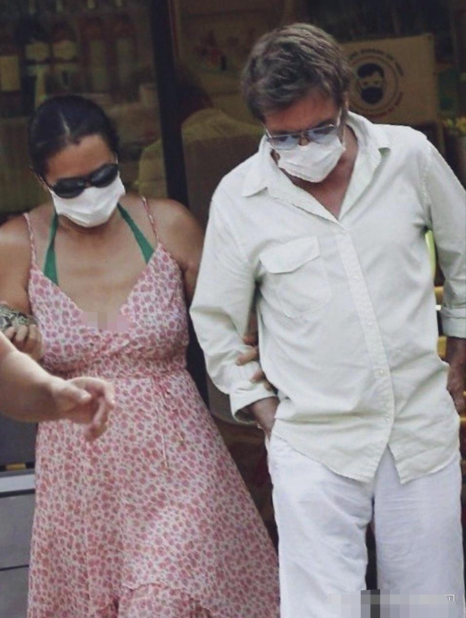 巩俐与丈夫让‑米歇尔·雅尔街头出行。巩俐挽住丈夫手臂，二人都佩戴口罩墨镜，松弛状