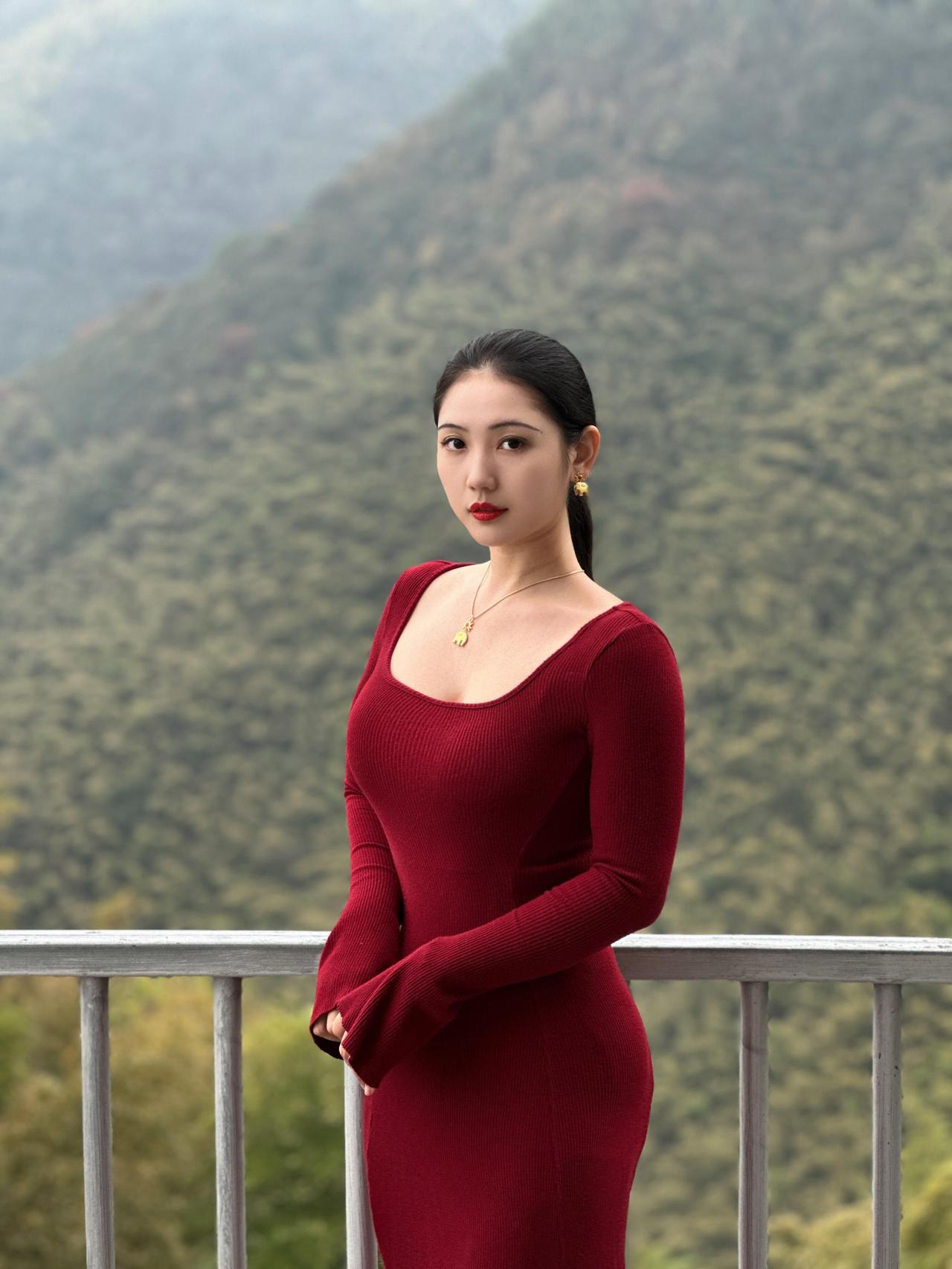 山雾漫过栏杆时，我正穿一身酒红，把发尾束成垂落的墨线。风裹着林野的潮气，蹭过