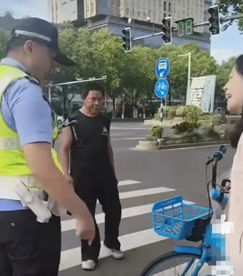 粉衣女把骑完的共享单车停放在人行道上，打算走人。结果被交警发现，要求其把车移走。