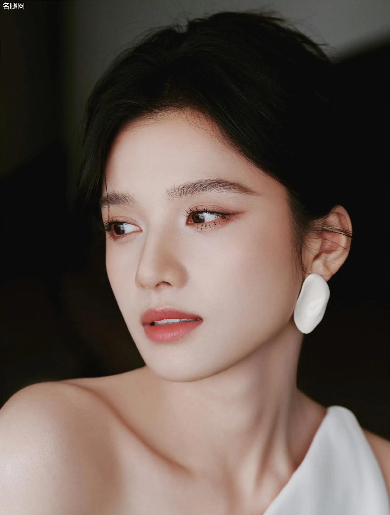 优雅女神张婧仪，一袭单肩白裙，勾勒利落线条，简约中藏着高级感。盘起的发、独特耳饰