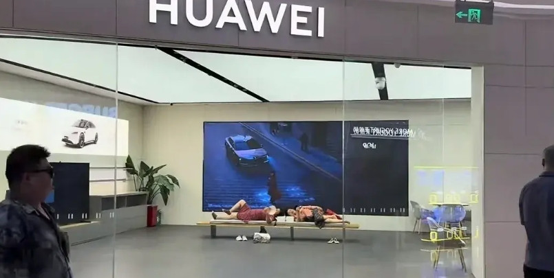 在华为躺平了的大妈因天气太热，两个大妈坐累了干脆躺在里面休息。虽然因为店里卖