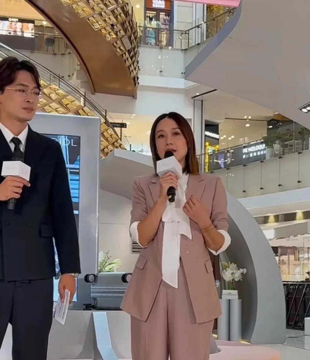 50岁的马伊琍站在上海RIMOWA开业剪彩台上，灰色西装袖子随手一挽，把中间位置让给了品牌方和年轻嘉