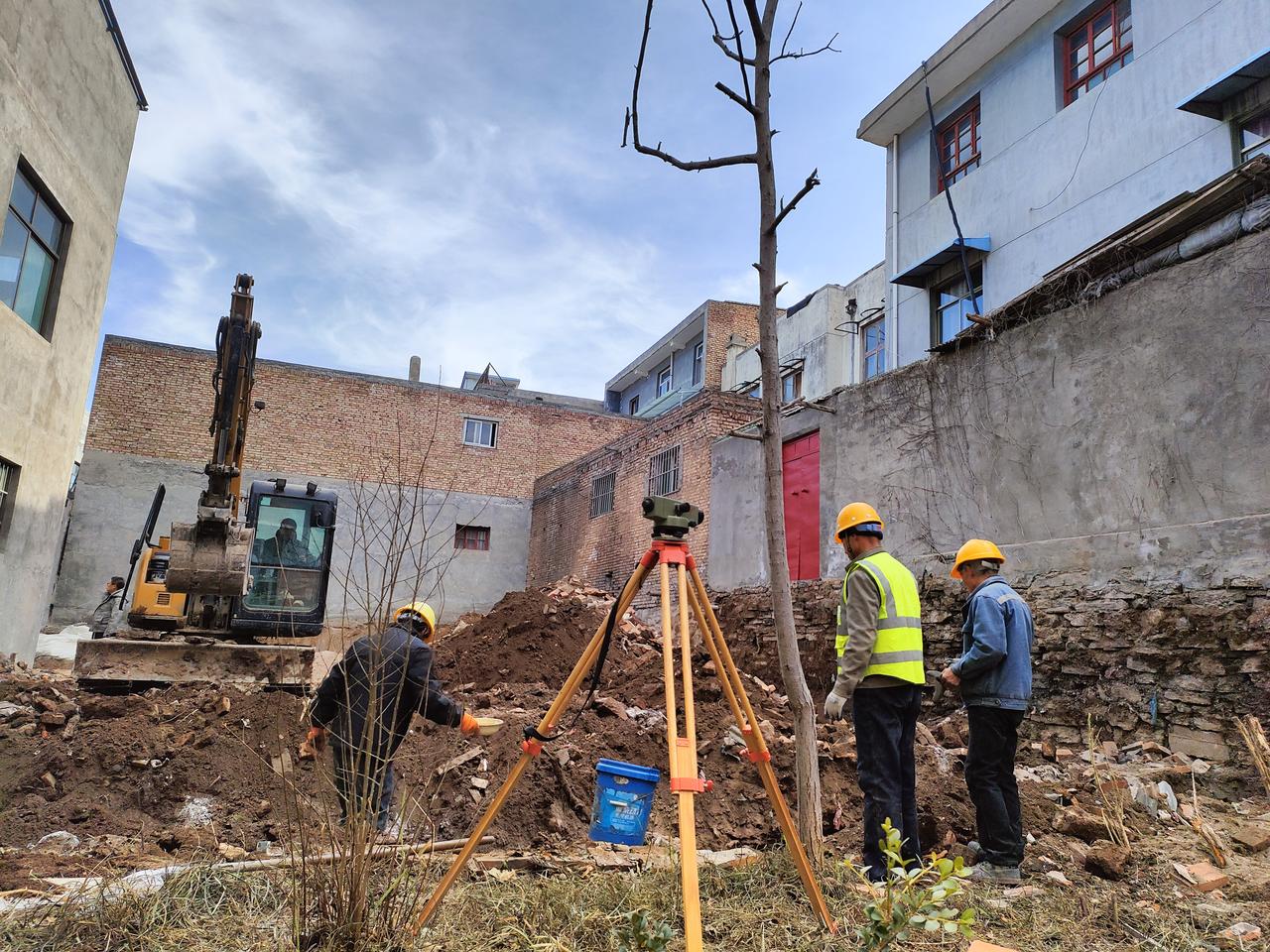 手机摄影随手发旧墙的砖屑混着新翻的泥土，全站仪支起丈量的标尺，挖掘机的铁臂悬在半