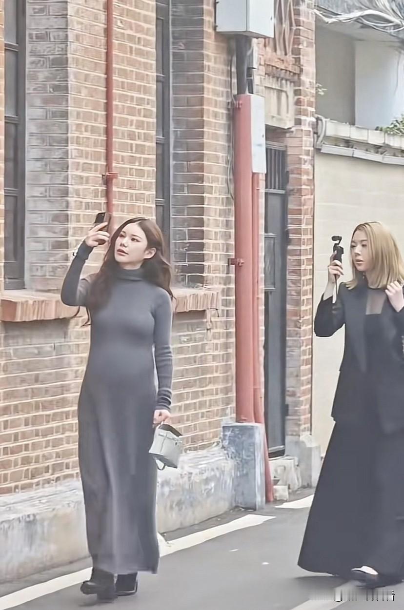 马筱梅挺着大肚子陪一家人游玩，走到街道拿出手机拍照，走到路口，一家人驻足讨论，小