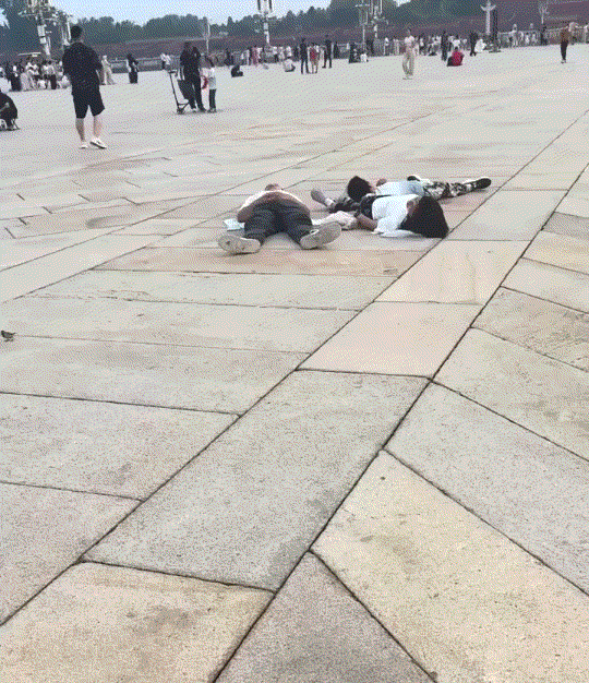 笑不活了！一家人前往北京天安门看升国旗，在等待过程中给，这一家竟集体躺平睡着了。