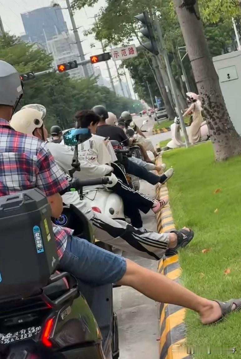 佛山的网友在一处红绿灯路口拍摄到了电鸡车主等红绿灯时的集体动作。只见前方的这一排