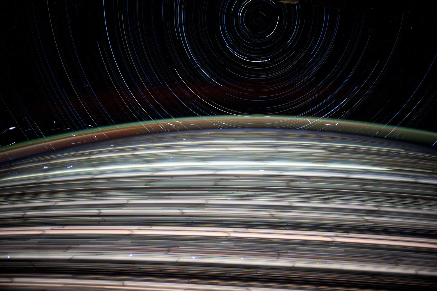 从国际空间站拍摄的星轨照片，星链卫星在遥远的大气层中点缀着细小的闪光，图源NAS