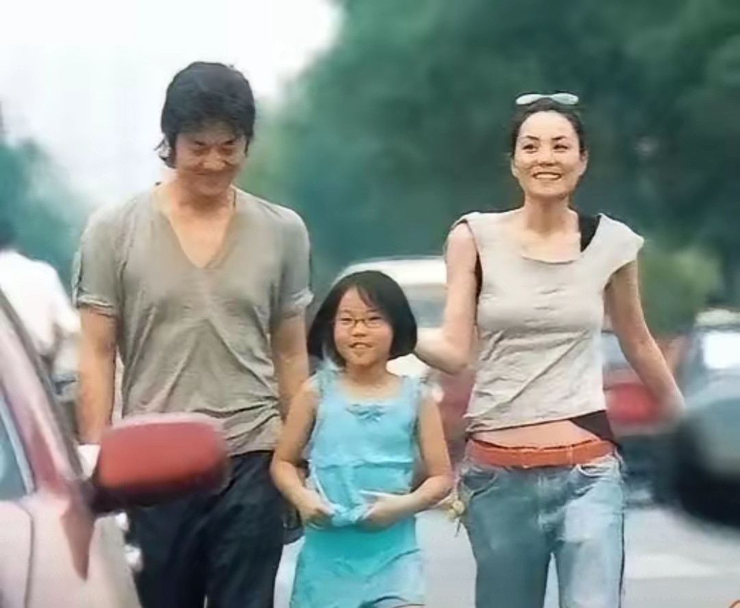 这张多年前街头随手拍下的照片，是王菲李亚鹏还在一起的时候，带着女儿李嫣出门散步。没有华丽的造型，没有