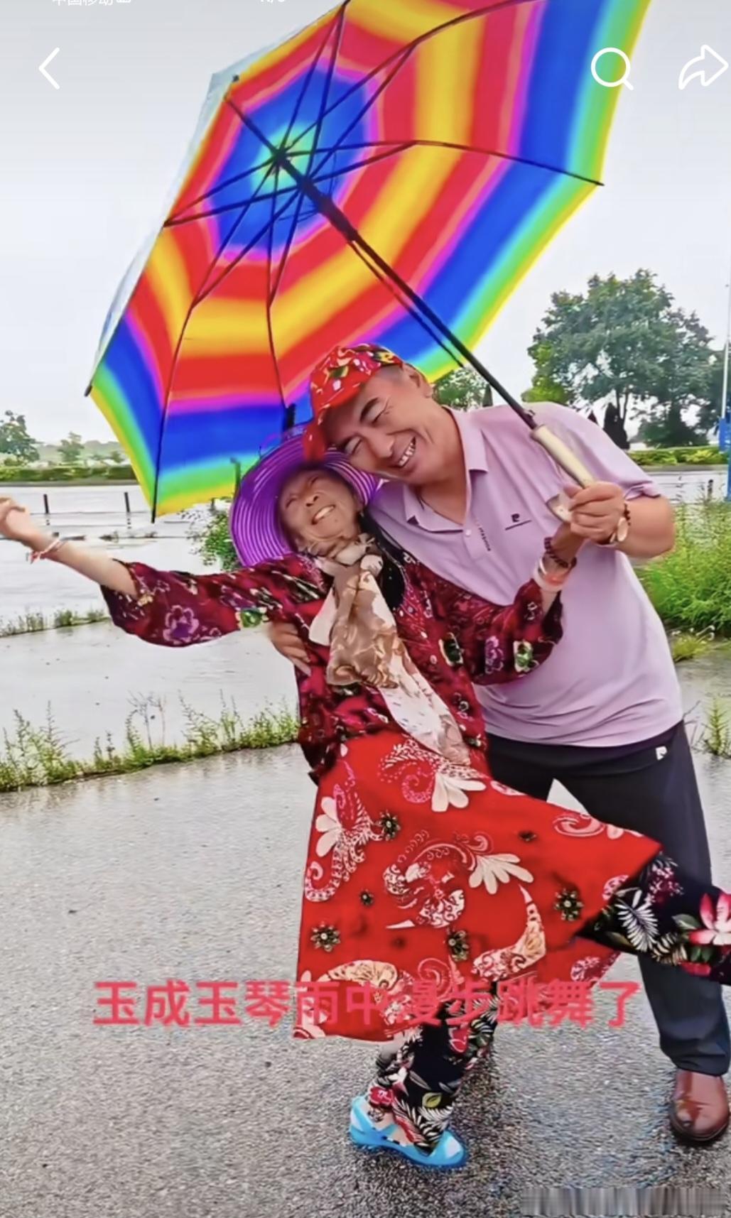 雨中翩翩起舞的马玉琴！看看马大姐这身行头，花袄，花裙子，花裤子，紫色太阳帽，红红