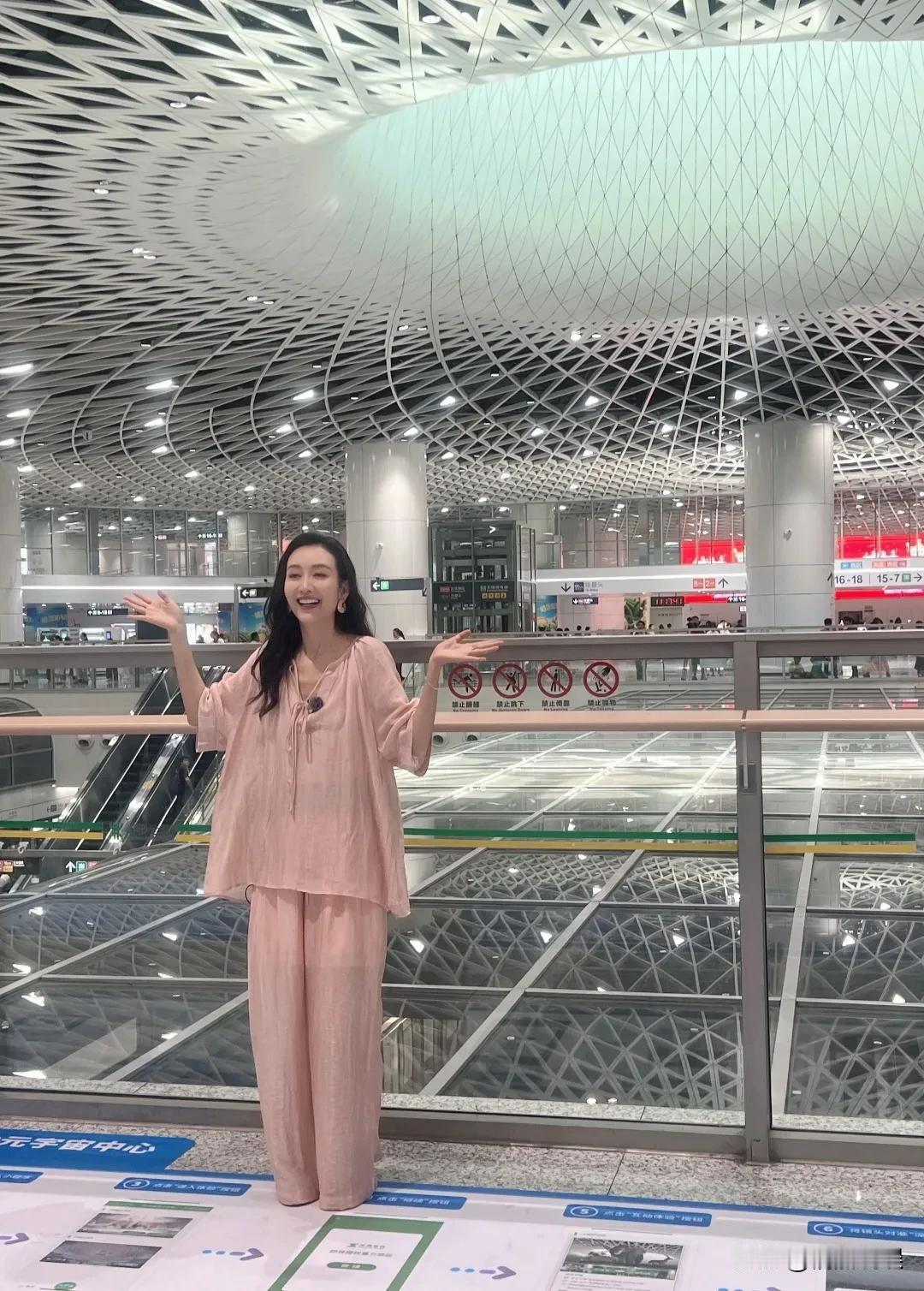 王鸥现身深圳，一头卷发披肩，皮肤白皙，笑容甜美，身材苗条，身上穿着自己设计的衣服