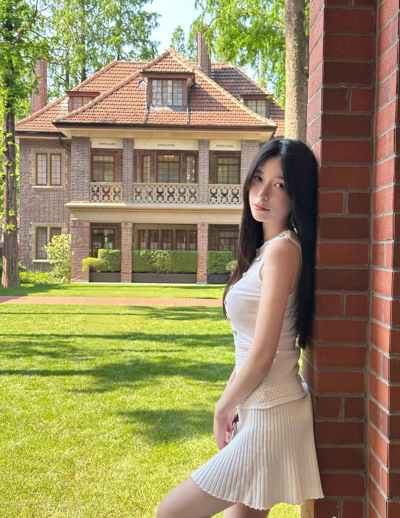 在红砖老洋房的光影里，邂逅一身温柔的白。阳光穿过树影，落在针织套装上，是独属于春