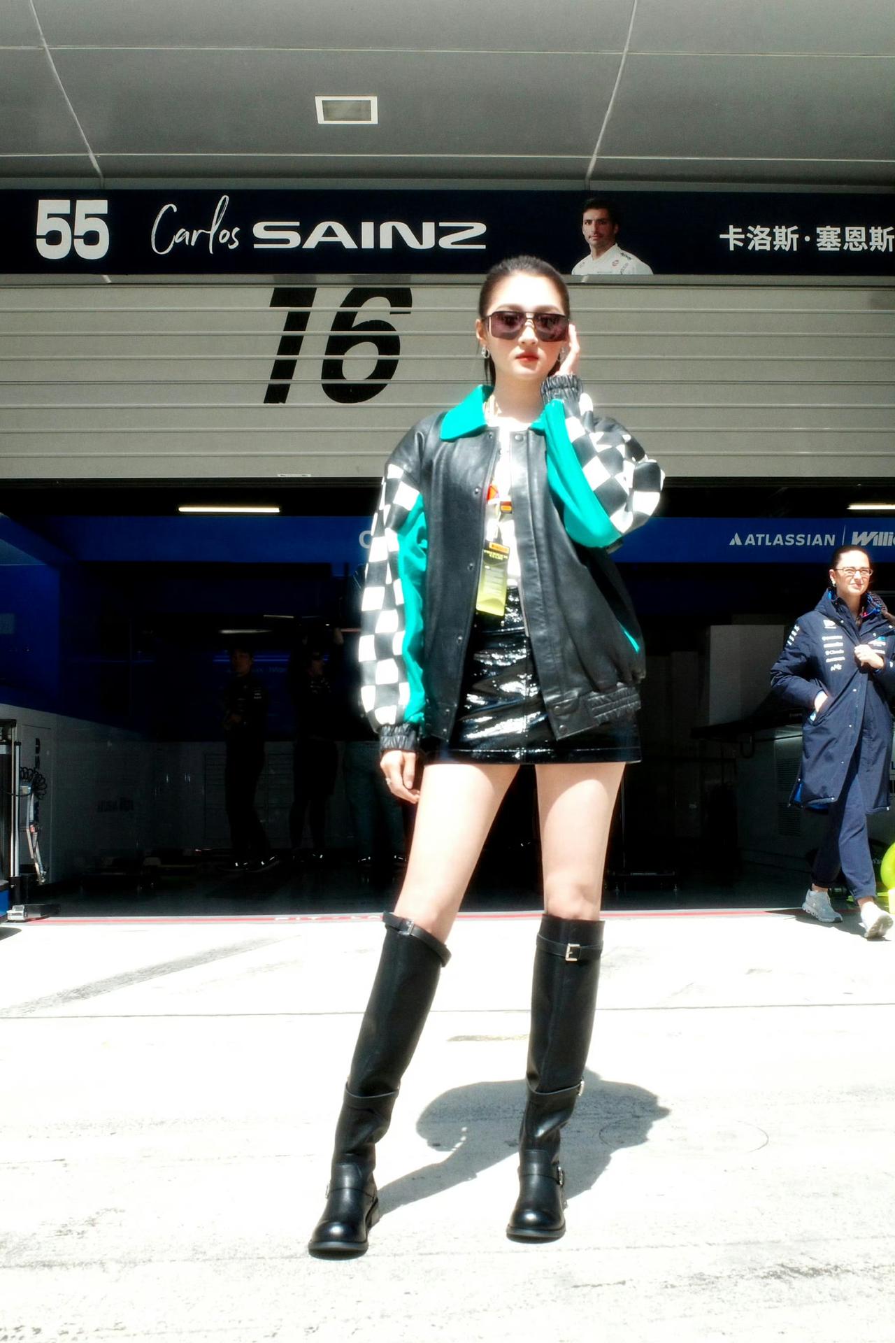 干净高马尾衬得脸更小，宽松拼色赛车外套藏住慵懒感，亮面短裙+过膝长靴直接拉长腿部