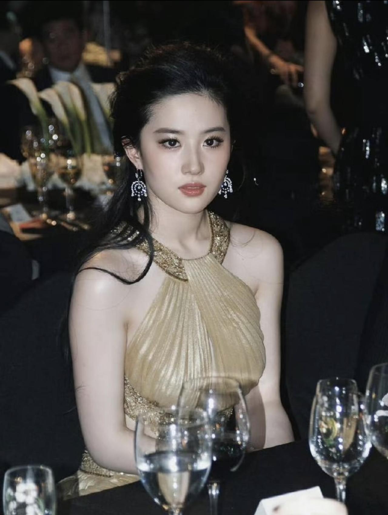 2010年，刘亦菲在上海参加第8届时尚芭莎明星慈善夜。刘亦菲大背头，戴着耳坠