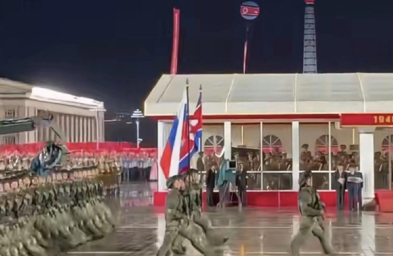 援俄部队亮相阅兵现场，他们举着两面旗帜，分别是朝鲜国旗和俄罗斯国旗，打朝鲜国旗可