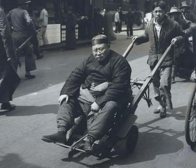 ‼️1938年，中国上海，一名商人被人用手推车推着走在街上。