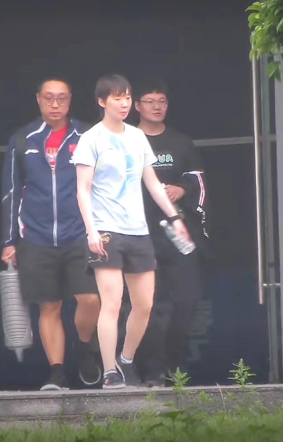 成都国乒训练基地，今天完成技术训练的王曼昱，与孟队医和体能教练一起走去训练体能的