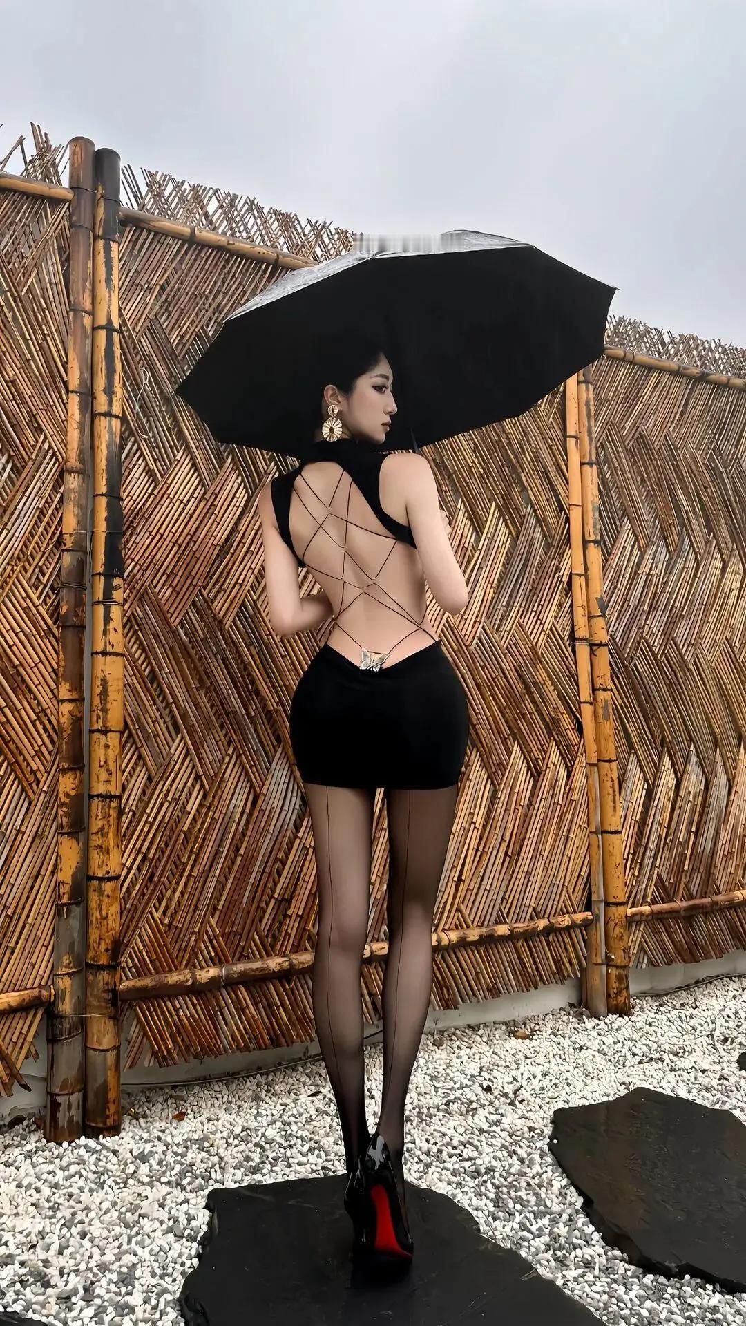 穿着时尚的女士撑伞拍照，民国是旗袍配油伞，现在则是漏背裙配遮阳伞。