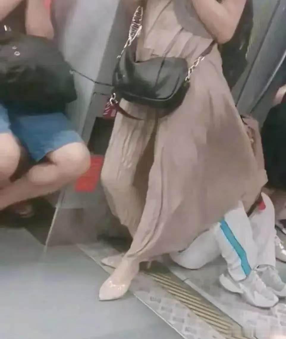 这个美女看手机太入迷了，自己的裙子吹人家头上，都盖住别人的脸了，她还不知道