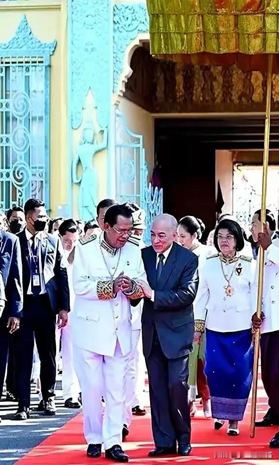 看看扶着洪森亲王的人是谁？这就是柬埔寨的西哈莫尼国王陛下。国王搀扶着首相，全世界