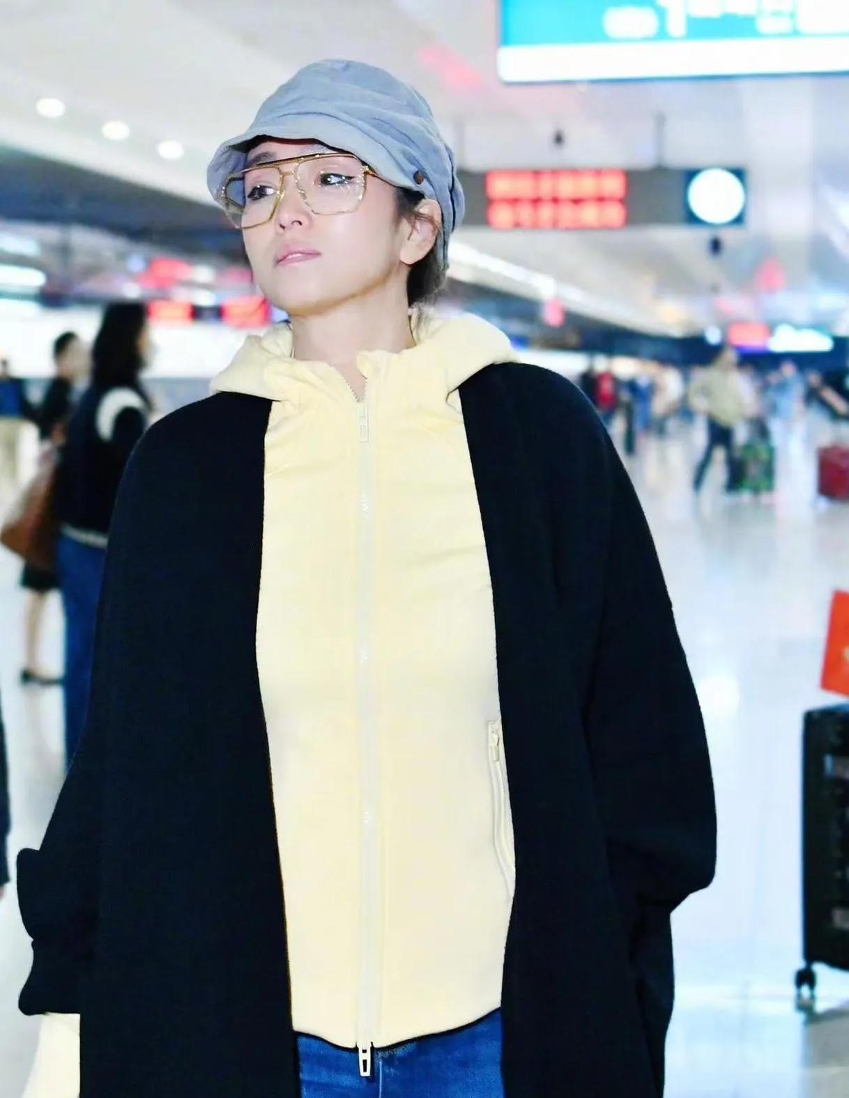 巩俐这新风格，是把“元气松弛感”焊在身上了吧！黑长开衫叠穿奶黄连帽衫，配牛