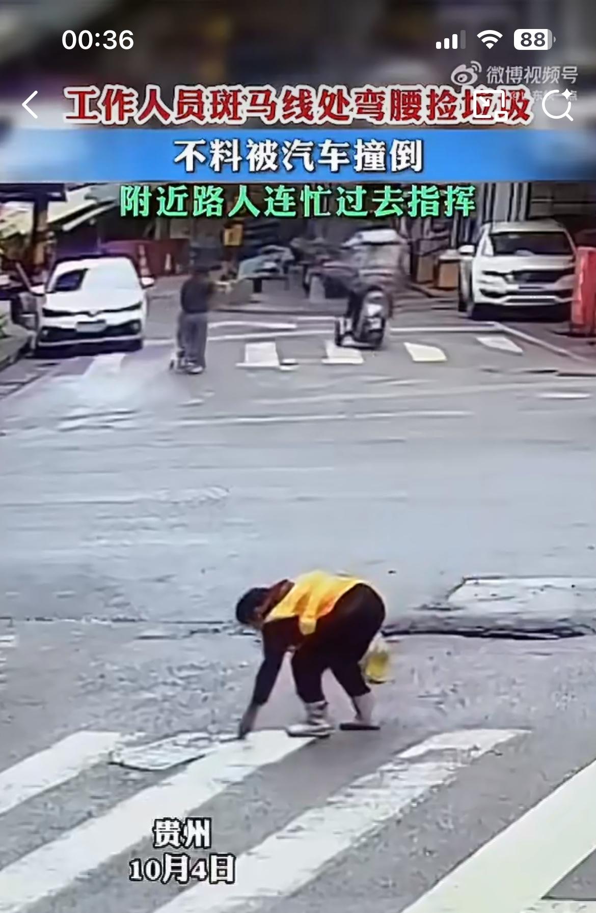贵州某地一街道，穿黄马甲的道路养护人员正走到马路中央捡垃圾，当他弯腰的瞬间被一辆