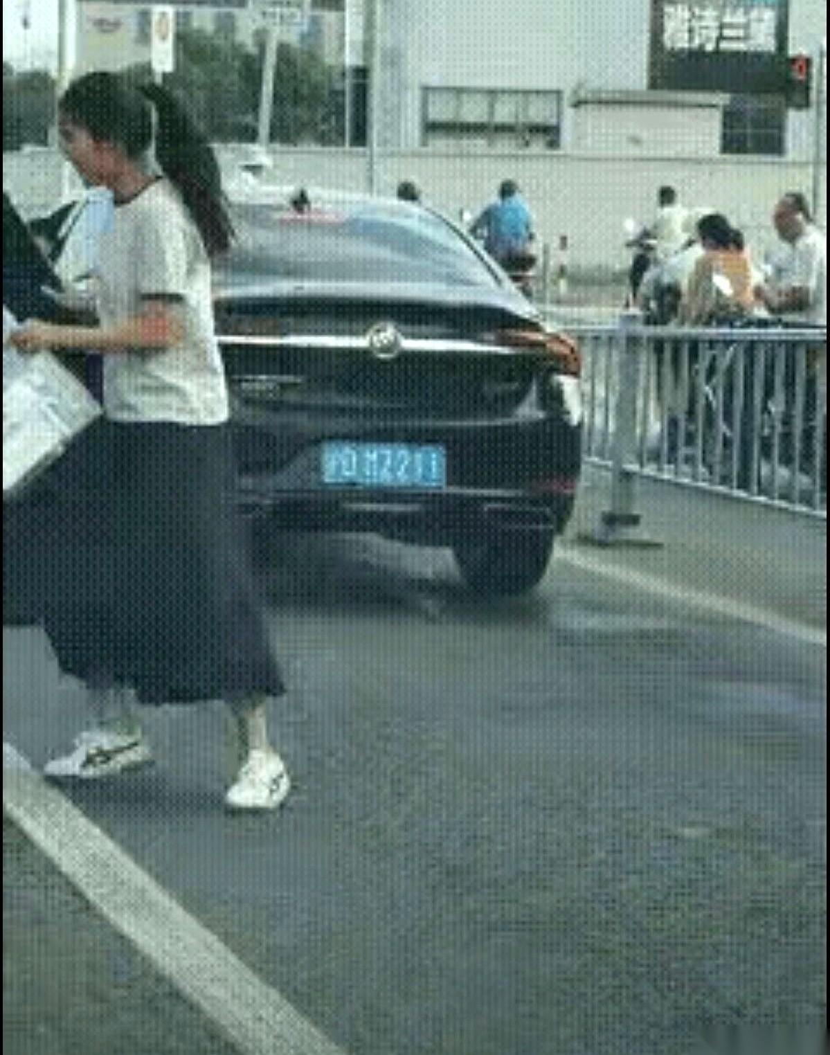 上海街头的十字路口，红灯亮起。一辆车牌号为“沪DMZ211”的轿车正停在斑马线前