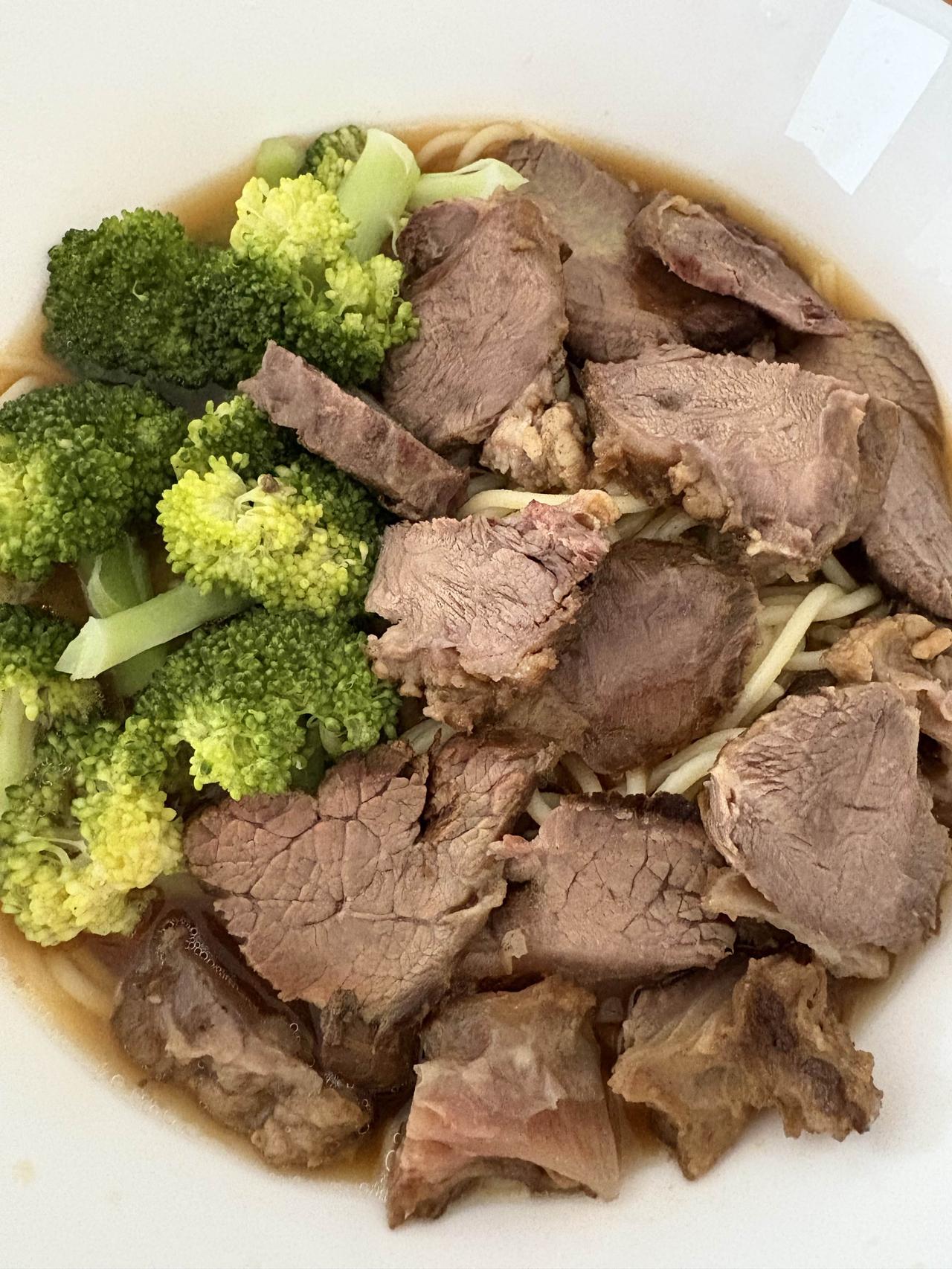 儿子最喜欢的牛肉面：煮好的意面打底，浇上牛肉汤，再放入蒜呢，胡椒粉，辣油，再码