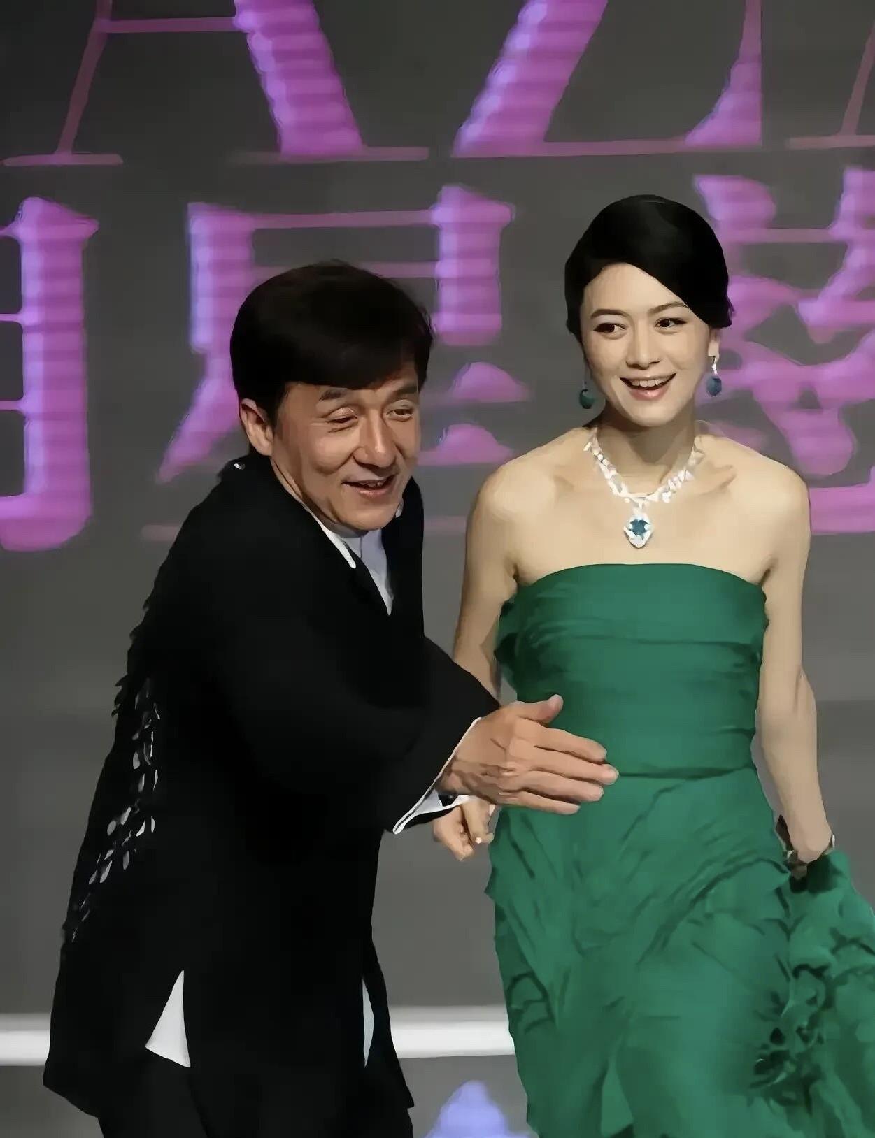 成龙大哥太有绅士风度了，弯着腰帮这位美女引路，你知道这一个女明星是谁吗？一袭绿色