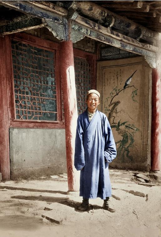 这张老照片里的，正是敦煌藏经洞的发现者王圆箓。他站在古旧的中式建筑檐下，身着宽