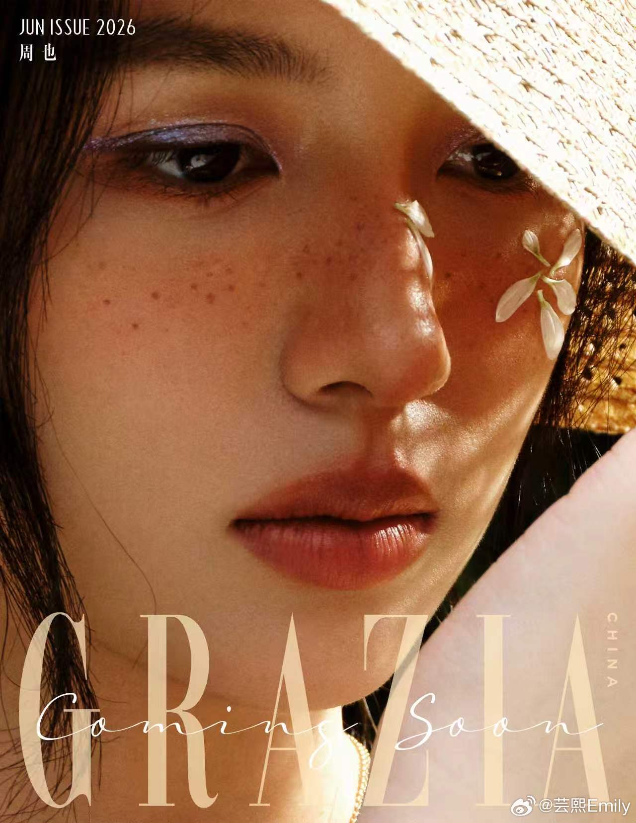周也红秀封面预告山野氛围感大片释出，草帽掩映眉眼，雀斑妆搭配面侧立体白花点缀，暖