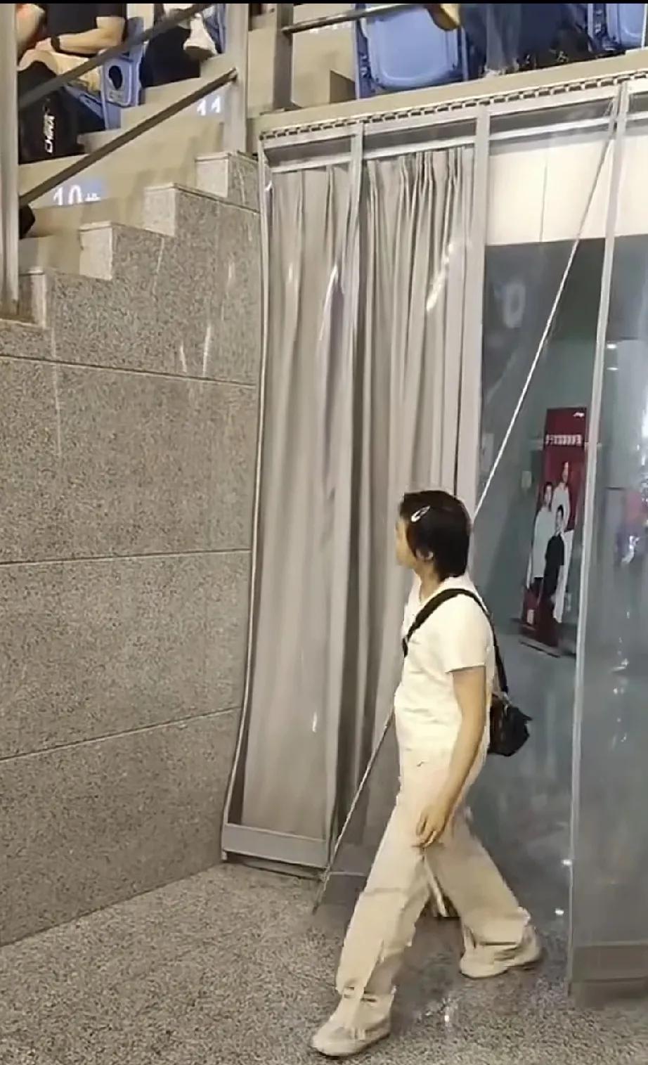 不参加比赛的全红婵走进场馆看台，发现没有座位，一屁股坐在台阶上。直率