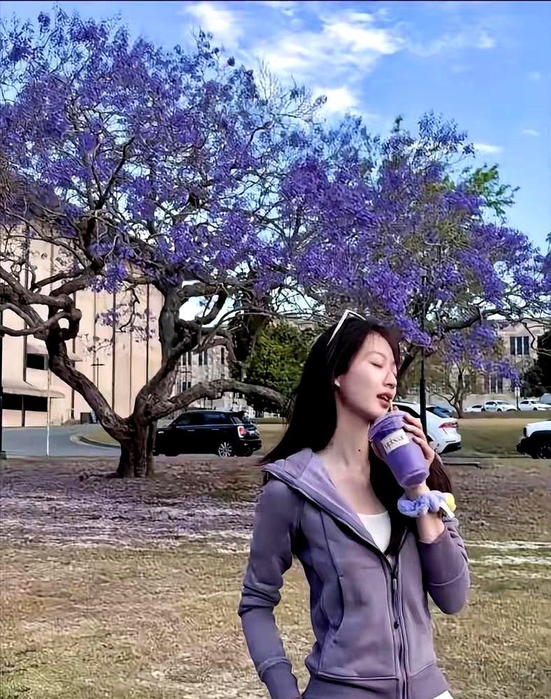 两人蹲在路边吃热狗，男友给她背着包，冯琳笑得很开心。这组在澳大利亚昆士兰拍的