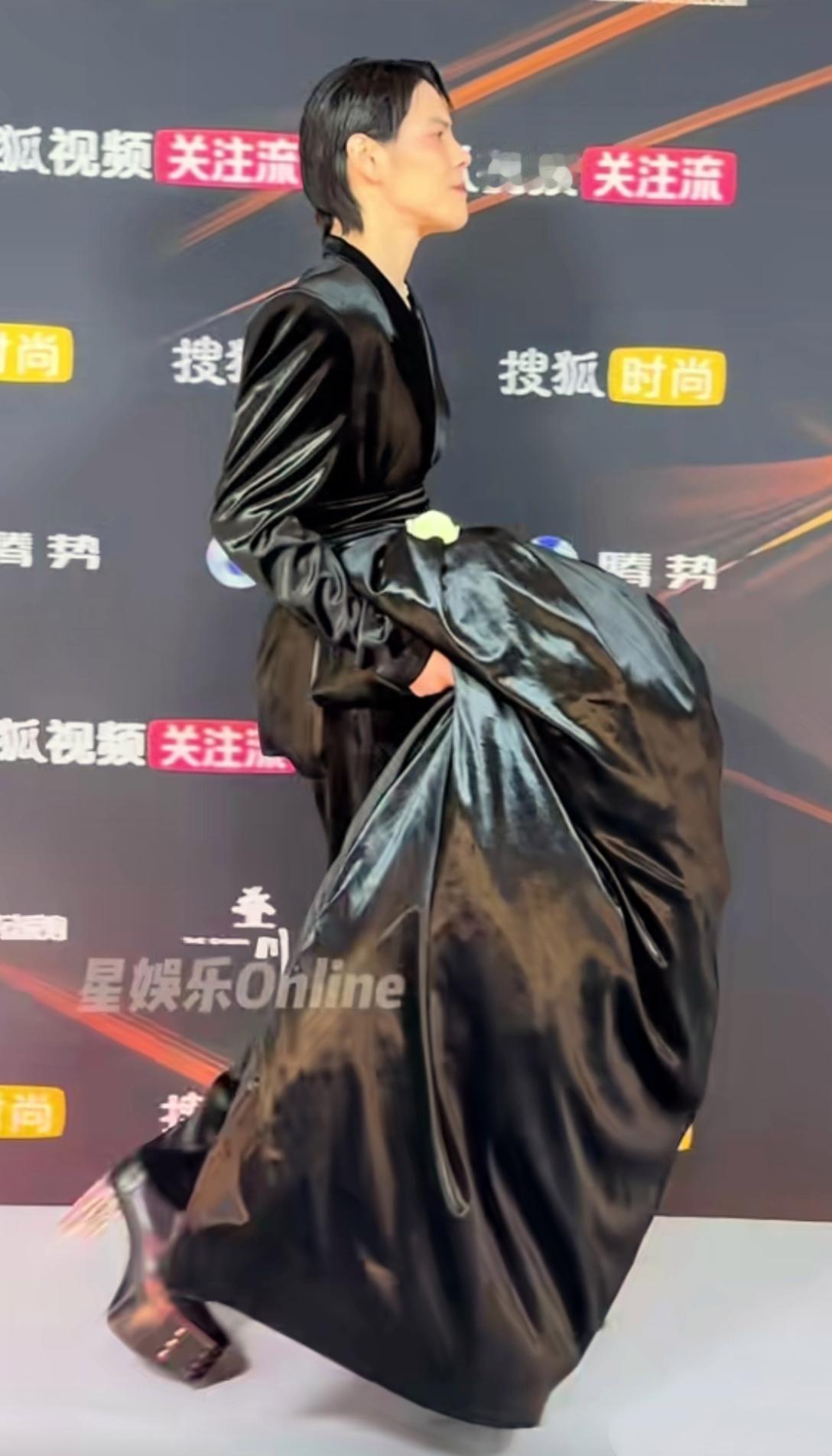 向佐最新活动造型：足登恨天高，身着大摆裙，高大修伟，螓首蛾眉，眼周染赤，唇若丹霞