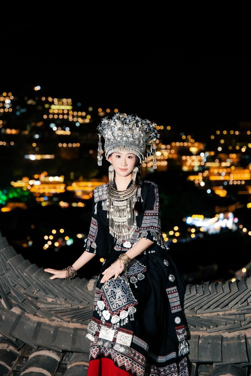 Angelababy现身贵州千户苗寨，身着精致苗族刺绣盛装，头戴沉甸甸的传统银饰