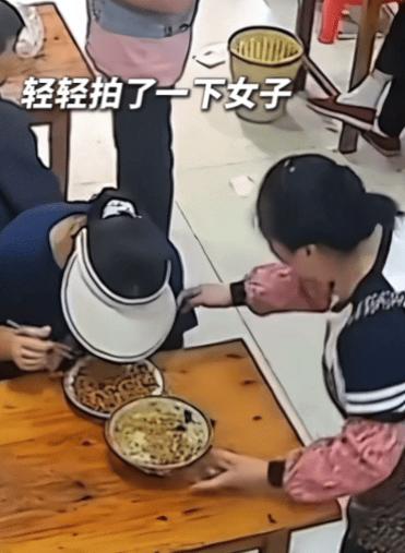 浙江，一餐馆老板，给一女顾客上菜。她看对方一直低着头吃饭，就轻拍了下对方，提醒菜