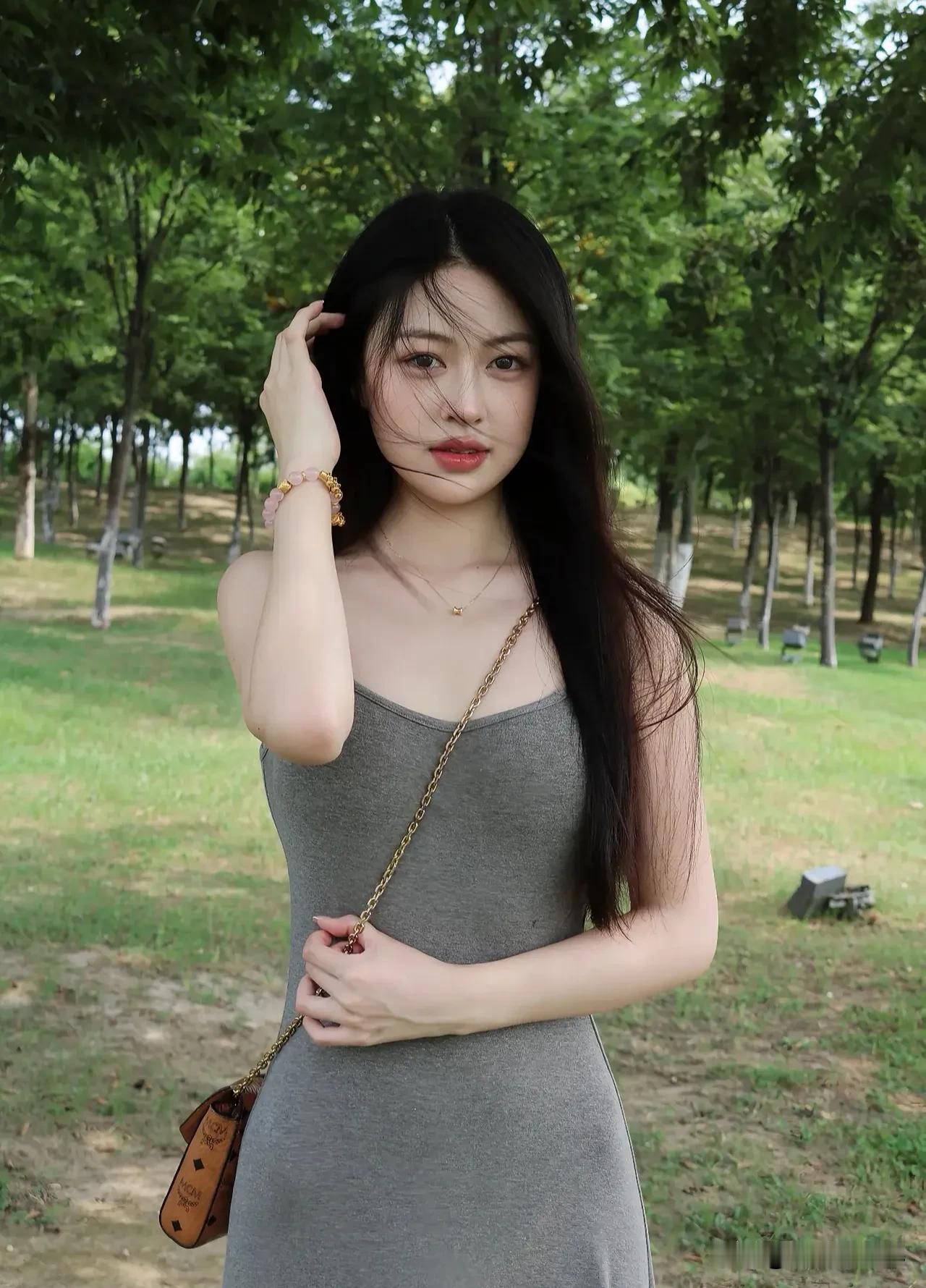 灰色吊带裙配绿茵，慵懒风里藏着少女心。午后阳光正好，随手一拍都