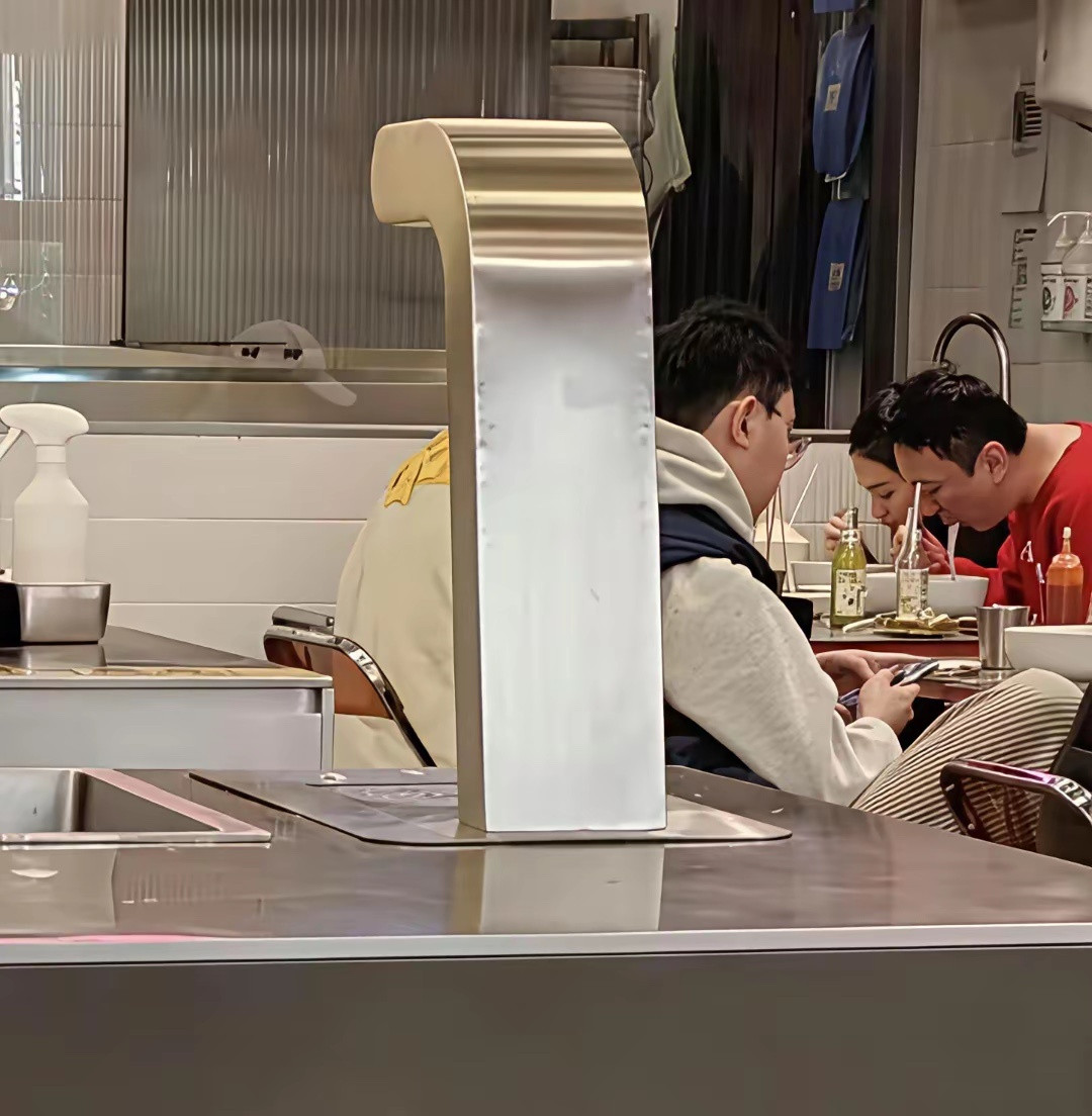 37岁王思聪带女友现身香港逛街，还到一家餐馆吃面条，他穿着粉红色上衣，身材微胖，