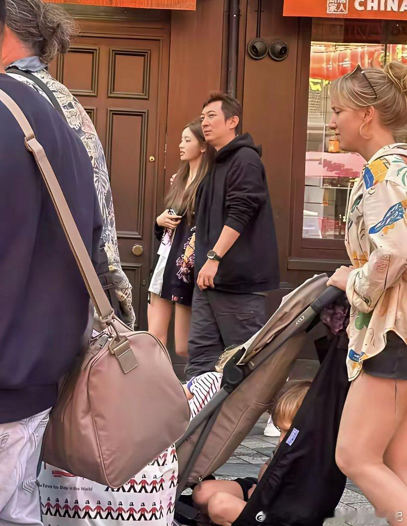 38岁王思聪和网红女友懒懒在伦敦唐人街被偶遇，两人边走边逛，他将手搭在女友的肩膀